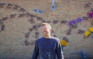 Artist Matt Willey in front of Bee Mural